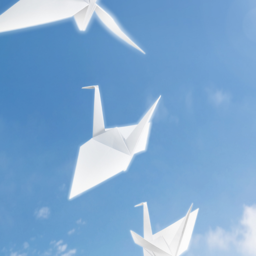 paper cranes being released into the sky