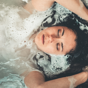 a woman laying in the bath with her eyes closed