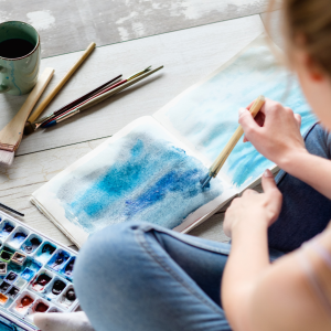 a woman doing a blue watercolor painting